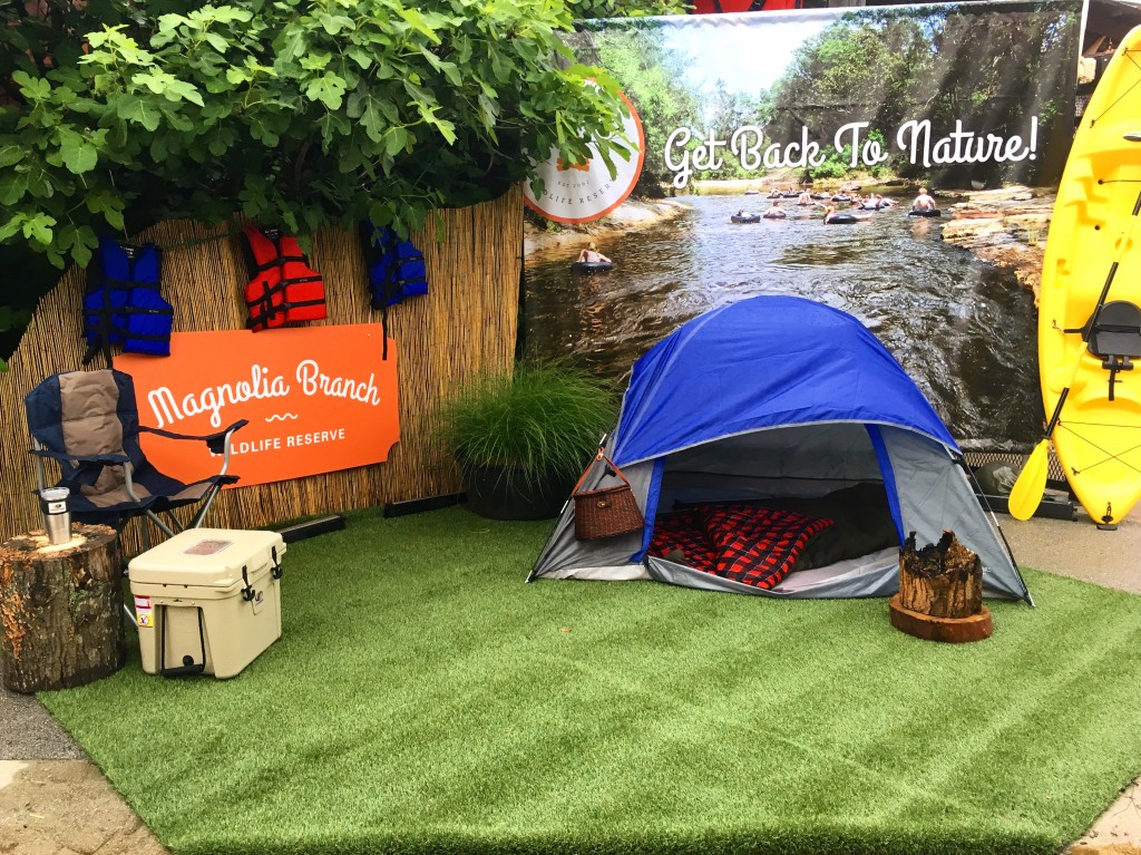 A colorful model campsite with a backdrop of Magnolia Branch Wildlife Reserve and the words, 